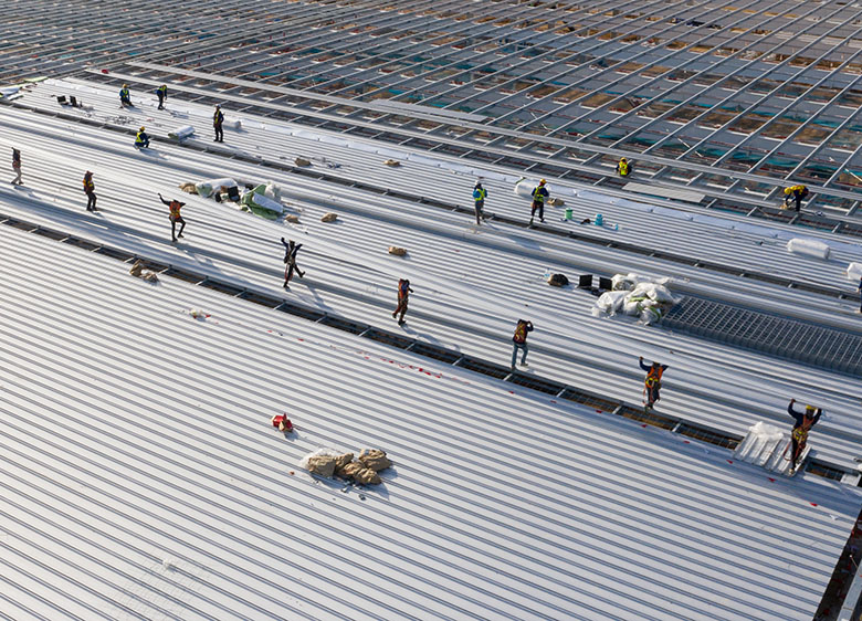 Aerial,View,By,Drone,Construction,Worker,At,Roof,Construction,Site